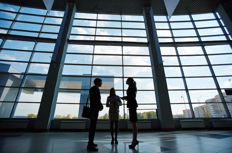 Three people standing and talking in a business building