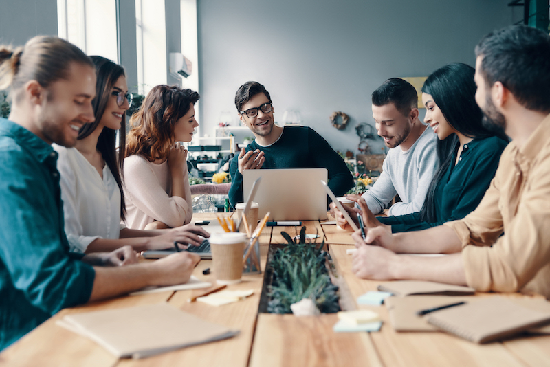Marketing team of young professionals brainstorming ideas around a conference table