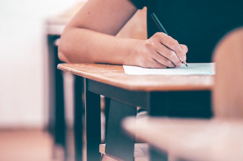 A high school student holding a pencil taking the sat test