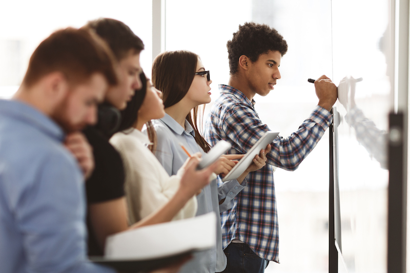 school school students transitioning to college writing on a white board with a marker