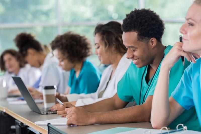 pre-med students sitting at a desk in glass working on assignments