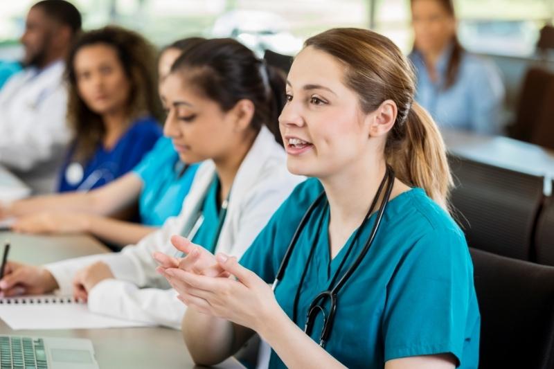 Pre-med student speaking in class sitting next to peers