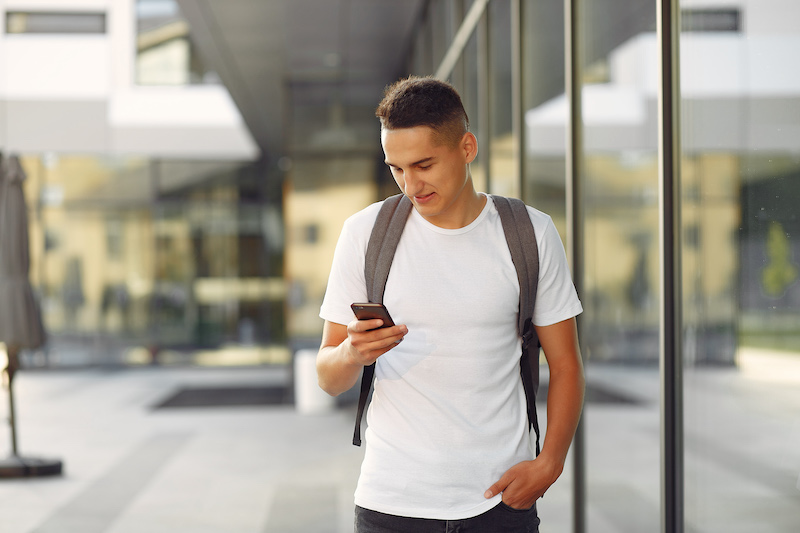 Student in a park. Boys in a university campus . Man with a phone.