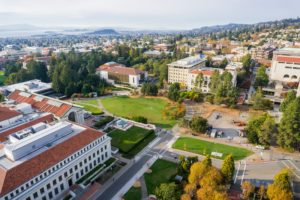 Aerial view of buildings in University of California, Berkeley campus on a sunny autumn day, view towards Richmond and the San Francisco bay shoreline in the background, California