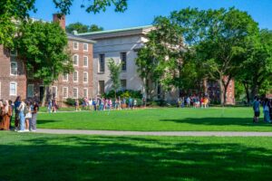 college university in the summer with students hanging out outside in the sun