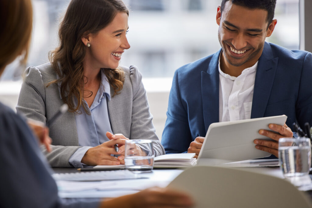 Two professionals discussing LSAT prep strategies with a tablet in a collaborative meeting setting