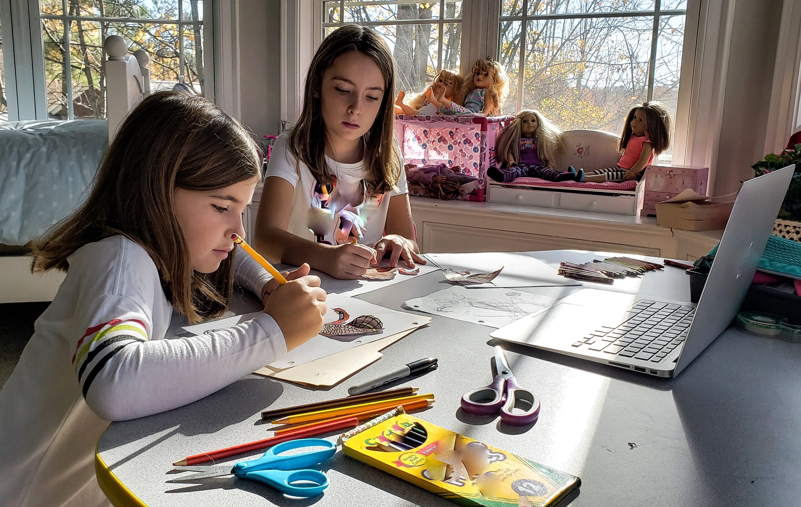 Young siblings at home doing art projects.