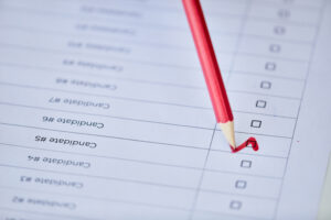 close up of red pencil and admission choices on piece of paper