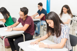 Group of teenage pupils taking test in classroom